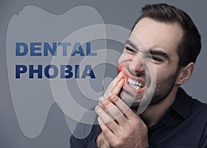 Dental phobia concept. Young man suffering from toothache on background