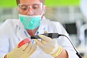 Dental prosthesis, dentures, prosthetics work. Prosthetics hands while working on the denture