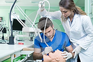 Dental prosthesis, dentures, prosthetics work. Prosthetics hands while working on the denture, false teeth, a study and a table wi