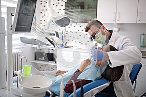 Dental specialist checking up patientâ€™s teeth