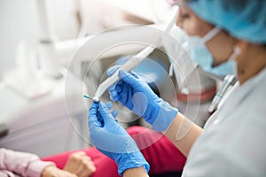 Dental surgeon putting on prophy cup on dental drill