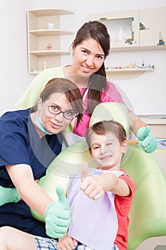 Dental team and young patient showing like