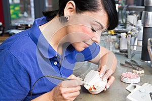 Dental technician applying wax to a mold to produce a prothesis