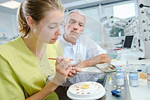 dental technician being supervised while working at prosthesis laboratory