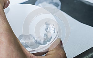 Dental technician is extracting teeth in the zirconia disc.