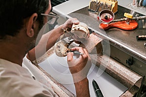 Dental technician fixing a dental prosthesis articulator