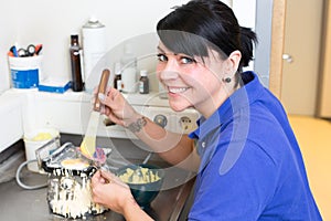 Dental technician in laboratory applying gypsum to a mold