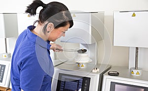 Dental technician in a laboratory taking ceramics out of the oven