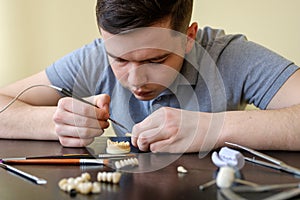 Dental technician modelling tooth crowns with hot wax