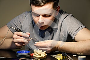 Dental technician modelling tooth crowns with hot wax