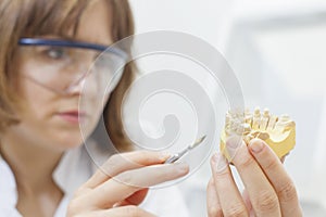 dental technician shaping a prosthesis tooth