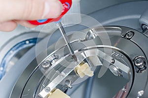 Dental technician unscrew the hybrid ceramics the milling machine. photo