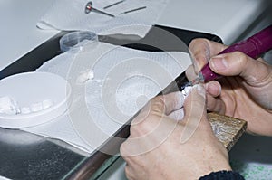 dental technician using dental burs with zirconium teeth.