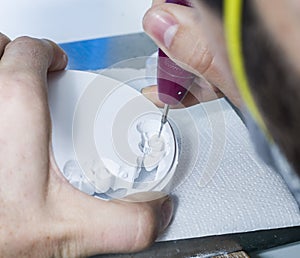 dental technician using dental burs with zirconium teeth. photo