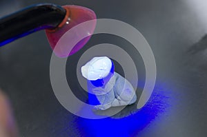 Dental technician using dental curing light in a tooth.
