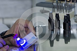 Dental technician using dental curing light in a tooth.
