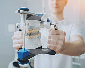 Dental technician working with articulator in dental lab