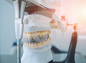 Dental technician working with articulator in dental lab