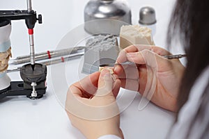 Dental technician working with articulator in dental laboratory