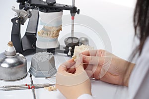 Dental technician working with articulator in dental laboratory