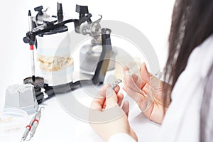 Dental technician working with articulator in dental laboratory