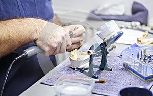 Dental technician working with articulator in dental lab