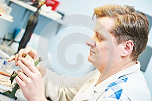Dental technician working with tooth dentures photo