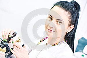 Dental technician works with prosthesis model photo