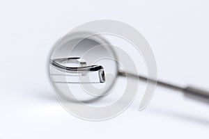 Dental tool reflected in the mirror on white background