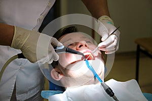 Dental tool for rinsing teeth. Teeth cleaning, dental hygiene. Dentist is rinsing of patient teeth with cleaning tool spray.