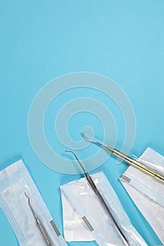 Dental tools in craft packages on a blue background.