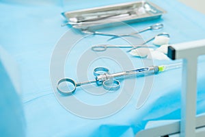 Dental tools and syringe at dentist`s surgery table on the background of . Selective focus. Space for text