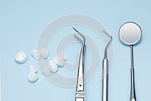 Dental tools and Zircon dentures on a blue background - Ceramic veneers - lumineers