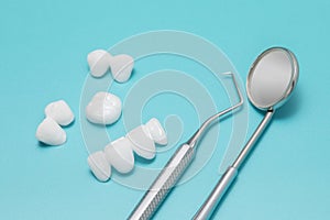 Dental tools and Zircon dentures on a blue background - Ceramic veneers - lumineers