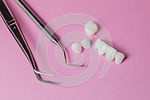 Dental tools with zircon dentures on a pink background - Ceramic veneers - lumineers