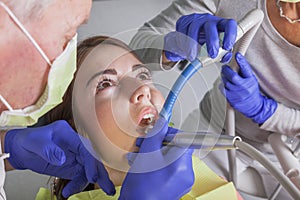 Dental treatment with drill and saliva sucker