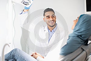 Dental Treatment. Middle Eastern Dentist Doctor Having Checkup With Muslim Female Patient