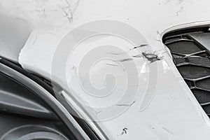 Dented wound and scratches on a damaged white car photo