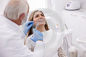 Dentist applying local anesthetic to female patient