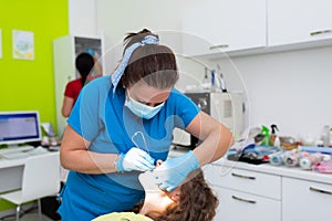 Dentist appointment at a dental clinic, placing braces locks on the teeth and pulling the archwire to fix it photo