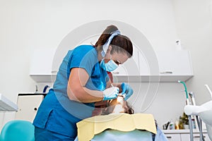 Dentist appointment at a dental clinic, placing braces locks on the teeth and pulling the archwire to fix it
