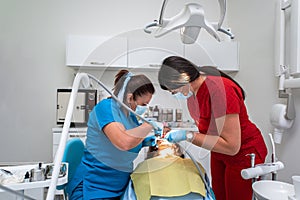 Dentist appointment at a dental clinic, placing braces locks on the teeth and pulling the archwire to fix it