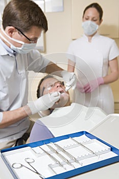 Dentist and assistant in exam room with man