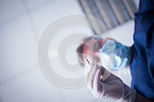 Dentist and assistant leaning over patient with tools
