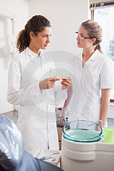 Dentist and assistant looking at mouth model