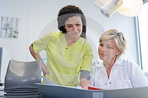 dentist and assistant with patient paperwork