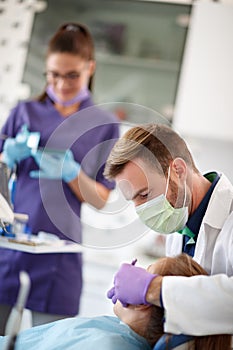 Dentist with assistant working in dental ambulant with patient