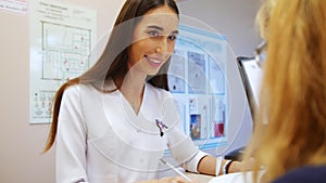 At the dentist. Beautiful woman dentist advises the patient to the woman who sits next.