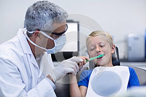 Dentist brushing a young patients teeth
