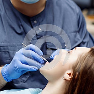 Dentist check-up teeth to young woman patient.